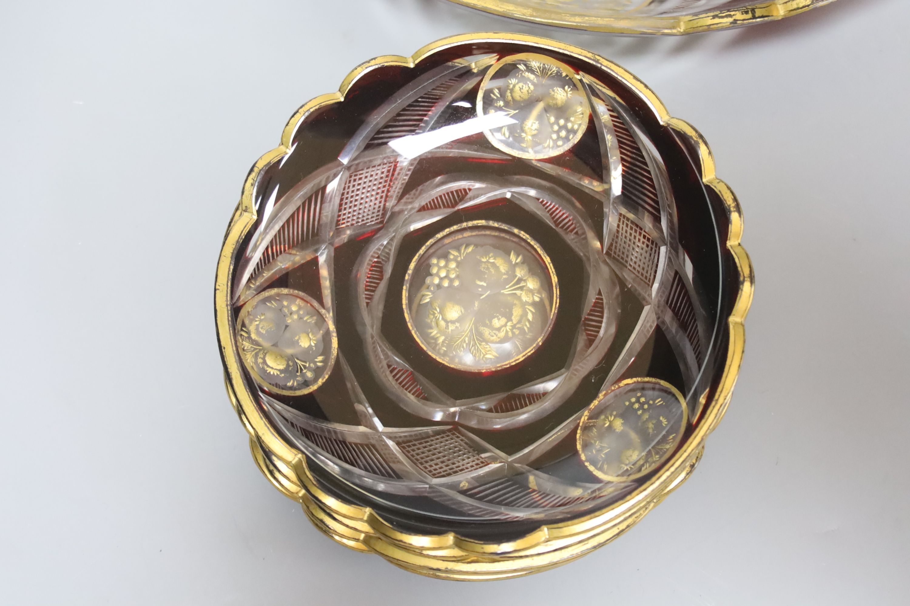 A late 19th century Bohemian intaglio cut and gilded glass dish and six saucers